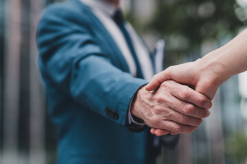 Close-up of a professional business handshake outdoors, symbolizing trust, partnership, and...