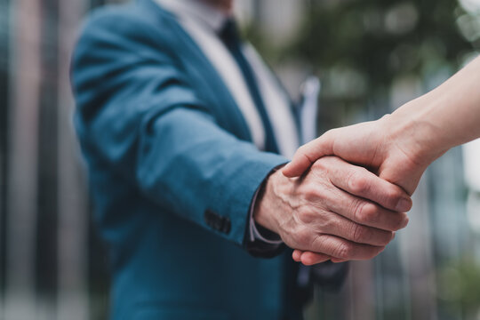 Close-up of a professional business handshake outdoors, symbolizing trust, partnership, and successful collaboration - Powered by Adobe