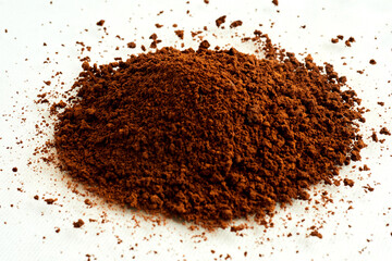 Ground coffee powder in a small mound isolated on white background
