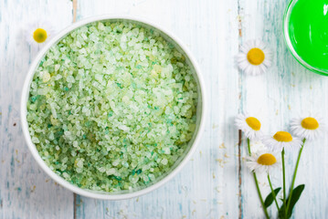 beauty product samples with chamomile flowers on white wooden table