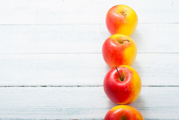 apple fruits in a row, white wooden table background