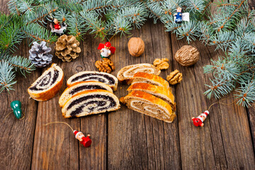 poppy and walnut roll cakes, santa and angel decorations, pine branch garland, old wood table