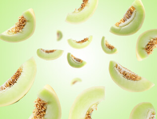 Cut fresh ripe melons swirling in air against green gradient background