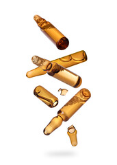 Many ampoules and glass pieces falling on white background
