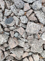 Close-up of rough granite rocks in natural colors, forming a textured stone background