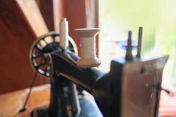 Vintage black sewing machine detail, retro craftsmanship, old technology, mechanical parts,...