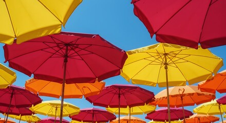 Colorful umbrellas in yellow red orange against clear blue sky