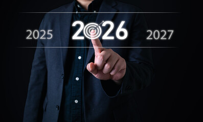 Goal setting concept with businessman pointing at 2026 on virtual screen with target icon,...