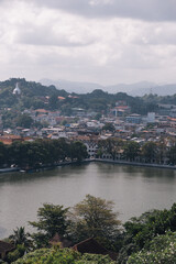 Aerial view of Kandy Lake reflecting surrounding buildings and lush vegetation under a cloudy sky in Kandy, Sri Lanka