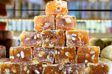 Stack of brown candies with nuts on top