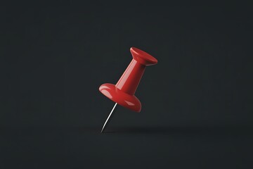 A single bright red pushpin with a sharp metal point on a dark background