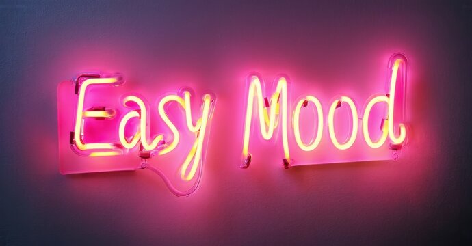 Bright pink neon sign displays cursive text reading Easy Mood. Wall background is softly illuminated, creating vibrant contrast. Simple, modern aesthetic.