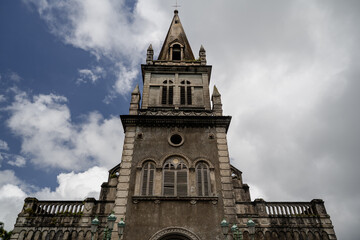 Obraz premium Majestic Church Tower with Dramatic Cloudy Sky - Architectural Marvel