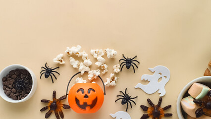candy, popcorn, chocolate in a bowl and a Halloween themed background with space for text