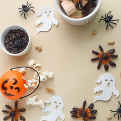 candy, popcorn, chocolate in a bowl and a Halloween themed background with space for text