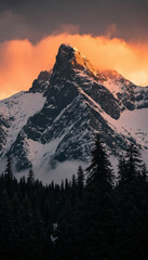 Obraz premium Golden Sunset Light on a Majestic Mountain Peak 