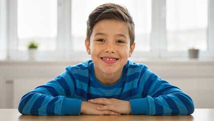 Boy in blue striped shirt sitting by window