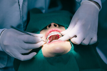 Dentist's hands fitting a retainer on a patient with braces during an orthodontic adjustment.