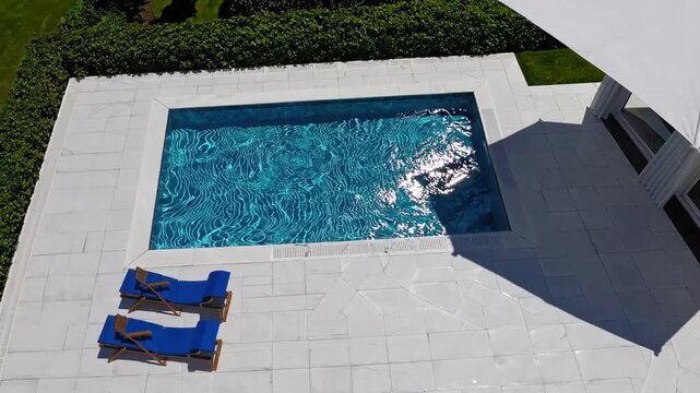 Aerial Top Down View of Outdoor Swimming Pool with Umbrella and Sun Lounger and Clear Water as Texture Background Concept