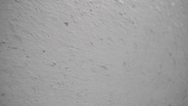 finished pale concrete wall texture serving as background, featuring grey antique plain hue with cement fissures containing sand and stone for seamless panoramic decorative design element
