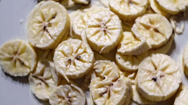 Elevated View of Large Quantity of Sliced Banana Fruit Arranged on Surface in graphic Studio Setting for Lifestyle