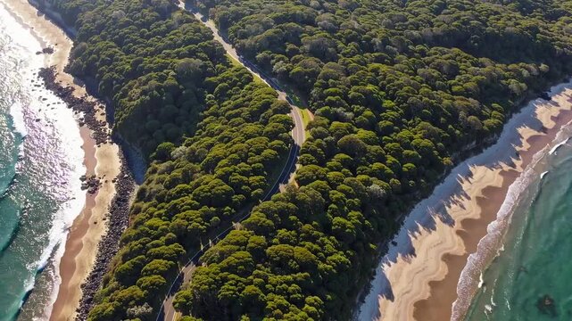 Drone footage of elevated pathway traversing scrubland illuminated by dawn's early light