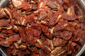 Sun-dried tomatoes fill a large metal bowl