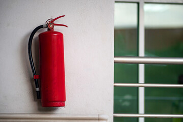 Red Fire Extinguisher on White Wall Background