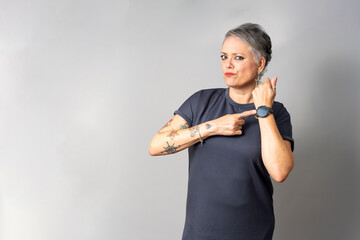 Woman pointing at wristwatch showing time punctuality deadline