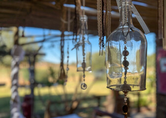 Bohemian looking homemade wind chime made from a an old, glass bottle and colored beads hanging...
