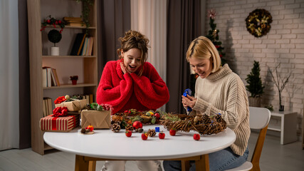Girlfriends Crafting Holiday Decor Together in Cozy Living Room During Winter Festivities