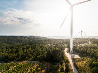 Backlit wind turbine in Terra Alta, Catalonia, Spain, symbolizing renewable power, modern technology, and the integration of energy production with Mediterranean nature.                     