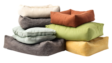 Cozy pile of colorful textured floor cushions and pet beds creating a comfortable modern decor arrangement isolated on white background
