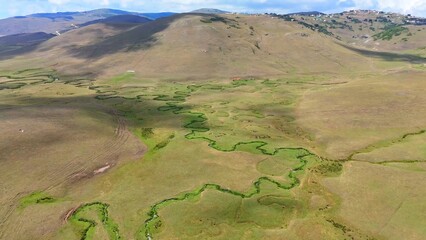 The Perşembe Yaylası is the summer pastureland of Perşembe district. Panoramic View of Meandering Stream and Majestic Mountains in Perşembe Plateau, Ordu, Turkiye.
