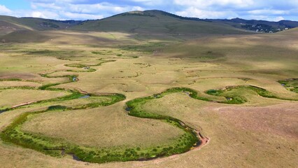 The Perşembe Yaylası is the summer pastureland of Perşembe district. Panoramic View of Meandering Stream and Majestic Mountains in Perşembe Plateau, Ordu, Turkiye.