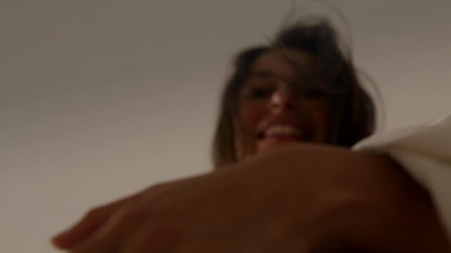 Pregnant woman dancing on bed with big belly - extreme close up