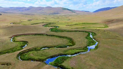 The Perşembe Yaylası is the summer pastureland of Perşembe district. Panoramic View of Meandering Stream and Majestic Mountains in Perşembe Plateau, Ordu, Turkiye.