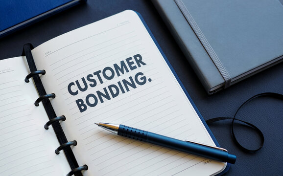 "CUSTOMER BONDING." text in a notebook with a pen, symbolizing strong business relationships, loyalty, and client engagement strategy.