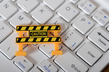 Digital Caution: Miniature Barrier on Keyboard Symbolizing Online Security and Cyber Threats.