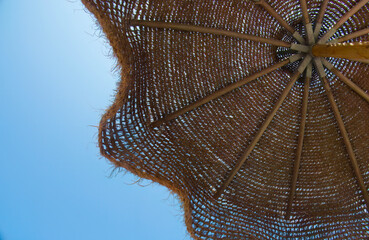 Stuffed fiber umbrella on the Mediterranean beach