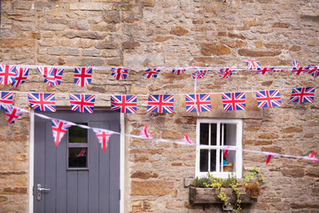 Authentic English countryside house with wavering flags of the United Kingdom