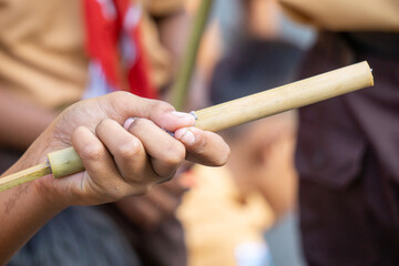 Playing tulup (Indonesian toy gun) made of bamboo. This gun is usually filled with bullets made from guava flowers, cassava leaves or wet paper.