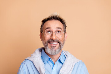 Confident senior businessman with glasses on beige background wearing casual elegant attire with a cheerful expression