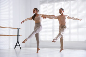Naklejka premium Couple of professional dancers training in studio