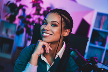 Charming attractive female blogger with microphone filming indoors under neon lighting for vlog or...