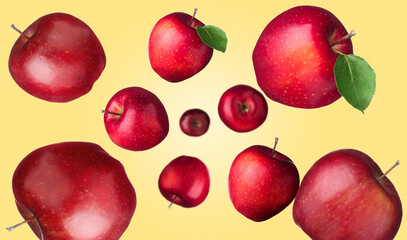 Fresh red apples swirling in air against pale orange background