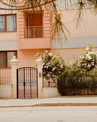 Cozy house with blooming roses near the gate, creating a charming and welcoming atmosphere.
