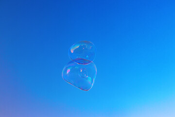 Soap bubbles against a blue sky background. Big bubbles floating in the air.