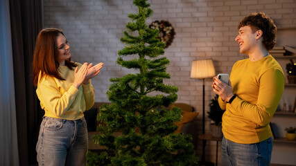 Friends Decorate a Living Room With a Festive Tree for the Upcoming New Year Celebration
