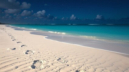 A serene beach scene under floodlights, featuring soft white sand, gentle waves, footprints in the sand